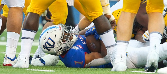 Kansas running back Pooka Williams Jr. (1) lays on his back under several West Virginia defenders after being stopped short of the goal line during the fourth quarter on Saturday, Sept. 21, 2019 at Memorial Stadium.