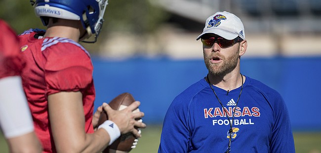 New Kansas offensive coordinator Brent Dearmon breaks down a drill with the KU quarterbacks, including starter Carter Stanley, during a recent practice. 