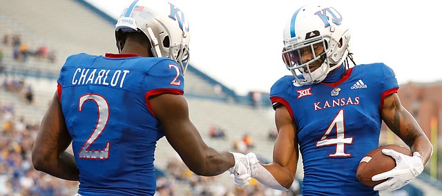 Kansas wide receiver Andrew Parchment (4) and Kansas wide receiver Daylon Charlot (2) celebrate Parchment's fourth-quarter touchdown with a handshake on Saturday, Sept. 21, 2019 at David Booth Kansas Memorial Stadium.