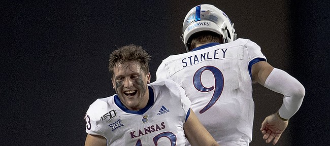 Kansas quarterback Carter Stanley (9) celebrates a touchdown against Texas with linebacker Jay Dineen (43) during an NCAA college football game Saturday, Oct. 19, 2019, in Austin, Texas. (Nick Wagner/Austin American-Statesman via AP)