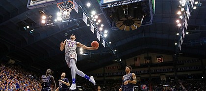 Kansas guard Tristan Enaruna (13) soars in for a breakaway dunk against Monmouth during the second half on Friday, Nov. 15, 2019 at Allen Fieldhouse.