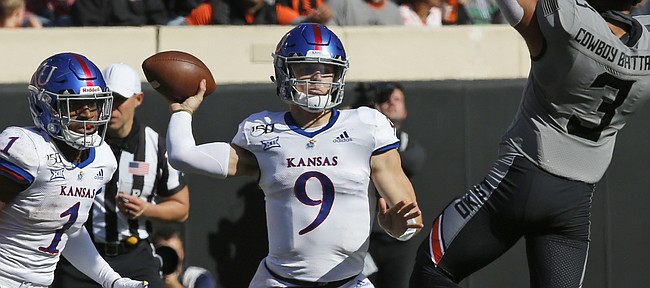 Kansas quarterback Carter Stanley (9) passes under pressure from Oklahoma State safety Tre Sterling (3) during an NCAA college football game in Stillwater, Okla., Saturday, Nov. 16, 2019. (AP Photo/Sue Ogrocki)