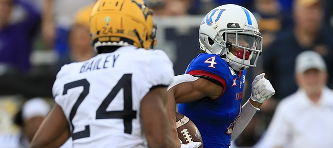 Kansas wide receiver Andrew Parchment (4) runs past West Virginia cornerback Hakeem Bailey (24) on his way to a touchdown during the second half of an NCAA college football game in Lawrence, Kan., Saturday, Sept. 21, 2019. (AP Photo/Orlin Wagner)