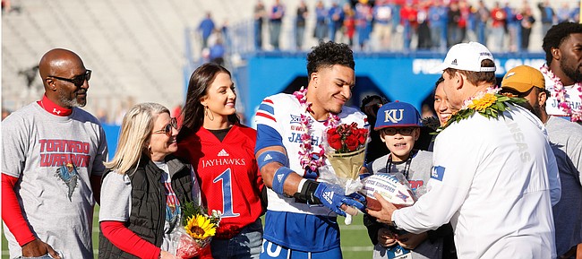 Kansas safety Bryce Torneden (1) receives a commemorative football from Kansas head coach Les Miles during the senior recognition ceremony on Saturday, Nov. 30, 2019 at Memorial Stadium.