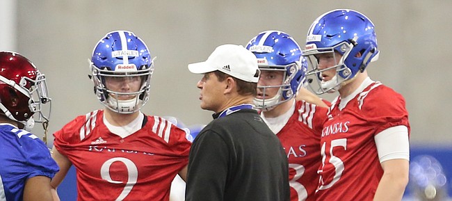 Kansas head coach Les Miles talks with quarterbacks and running backs during football practice on Wednesday, March 6, 2019 within the new indoor practice facility.