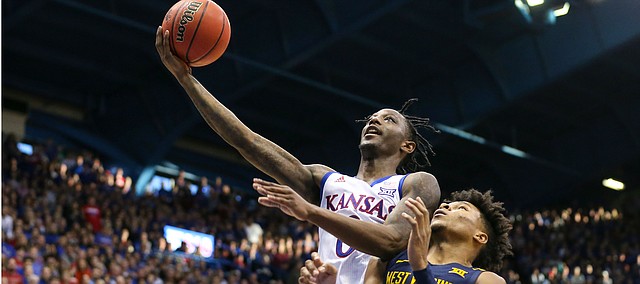 Kansas guard Marcus Garrett (0) gets in for a bucket past West Virginia guard Miles McBride (4) during the second half, Saturday, Jan. 4, 2020 at Allen Fieldhouse.