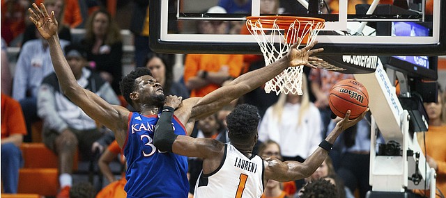Oklahoma State guard Jonathan Laurent (1) leans on Kansas center Udoka Azubuike (35) while taking a shot during the second half of an NCAA college basketball game in Stillwater, Okla., Monday, Jan. 27, 2020. Kansas defeated Oklahoma State 65-50. (AP Photo/Brody Schmidt)