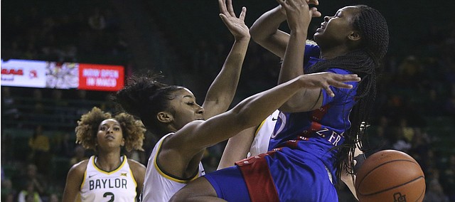 Kansas guard Zakiyah Franklin (15) loses the ball as she collides with Baylor guard Te'a Cooper (4) while driving to the basket in the first half of an NCAA college basketball game Wednesday, Feb. 5, 2020, in Waco, Texas. (AP Photo/ Jerry Larson)