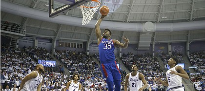 Kansas center Udoka Azubuike (35) dunks against TCU defenders guard Edric Dennis (2), PJ Fuller (4,) Kevin Samuel (21) and Charles O'Bannon Jr. (5) during the first half of an NCAA college basketball game, Saturday, Feb. 8, 2020, in Fort Worth, Texas. (AP Photo/Ron Jenkins)