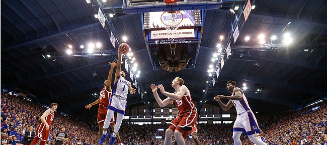Kansas guard Devon Dotson (1) gets in for a bucket past Oklahoma guard Jamal Bieniemy (24) during the first half on Saturday, Feb. 15, 2020 at Allen Fieldhouse.