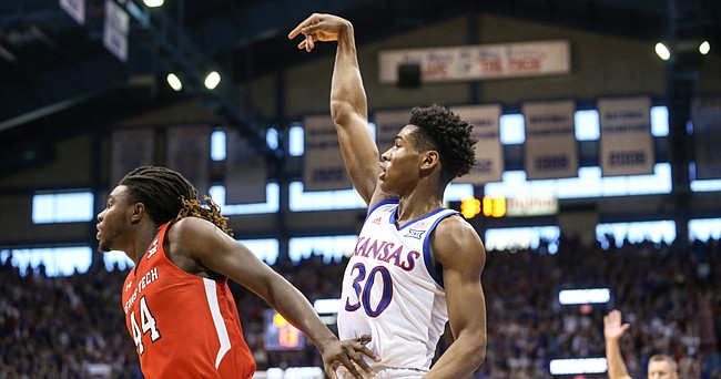 Kansas guard Ochai Agbaji (30) hangs his hand after hitting a three over Texas Tech guard Chris Clarke (44) from the corner during the first half, Saturday, Feb. 1, 2020 at Allen Fieldhouse.