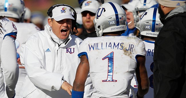 Kansas head coach Les Miles, left, congratulates Kansas running back Pooka Williams, right, after a touchdown by Williams during the second half of an NCAA college football game against Iowa State, Saturday, Nov. 23, 2019, in Ames, Iowa. Iowa State won 41-31. (AP Photo/Matthew Putney)