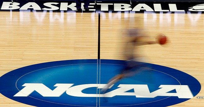In this March 14, 2012, file photo, a player runs across the NCAA logo during practice in Pittsburgh before an NCAA tournament college basketball game. (AP Photo/Keith Srakocic, File)

