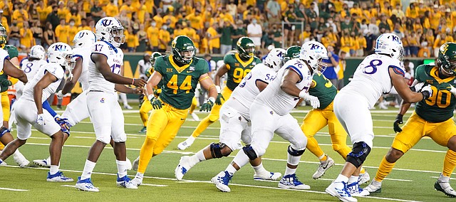The Kansas football offensive line blocks in front of quarterback Jalon Daniels on a pass play in Waco, Texas, on Sept. 26, 2020.