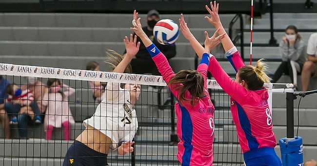 KU's Caroline Crawford (9) and Anezka Szabo (8) elevate at the net for a block attempt during the fourth set of the Jayhawks' five-set loss to the Mountaineers on Saturday, Oct. 10, 2020 at Horejsi Family Volleyball Arena.