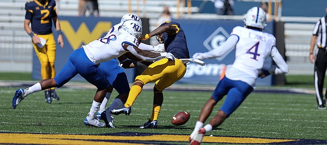 MORGANTOWN, WV - OCTOBER 17: West Virginia Mountaineers wide receiver T.J. Simmons (1) fumbles lbles after bring hit by Kansas Jayhawks linebacker Denzel Feaster (18) after catching a pass during the first quarter of the college football game between the Kansas Jayhawks and the West Virginia Mountaineers on October 17, 2020, at Mountaineer Field at Milan Puskar Stadium in Morgantown, WV.