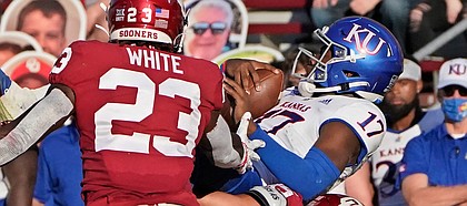 Kansas quarterback Jalon Daniels (17) is upended by Oklahoma linebacker Shane Whitter (35) in the first half of an NCAA college football game in Norman, Okla., Saturday, Nov. 7, 2020. (AP Photo/Sue Ogrocki)