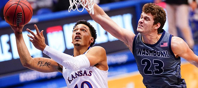 Kansas forward Jalen Wilson (10) gets under Washburn forward Will McKee (23) for a shot and a foul during the first half on Thursday, Dec. 3, 2020 at Allen Fieldhouse.