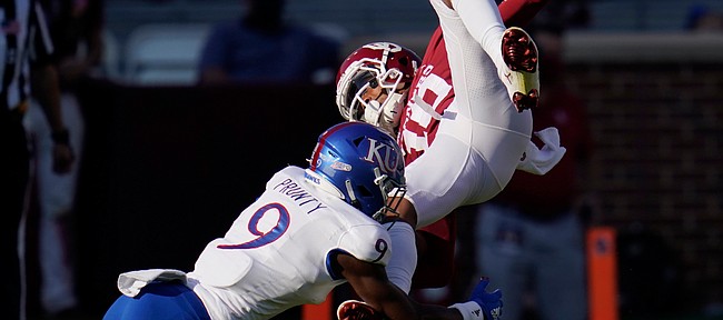 Oklahoma wide receiver Theo Wease (10) is upended by Kansas cornerback Karon Prunty (9) in the first half of an NCAA college football game in Norman, Okla., Saturday, Nov. 7, 2020. (AP Photo/Sue Ogrocki)