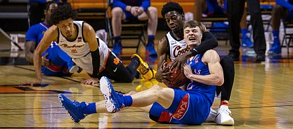 Oklahoma State's Bryce Williams, right rear, and Kansas' Christian Braun scramble for the ball during the first half of an NCAA college basketball game in Stillwater, Okla., Tuesday, Jan. 12, 2021. A jump ball was called. (AP Photo/Mitch Alcala)