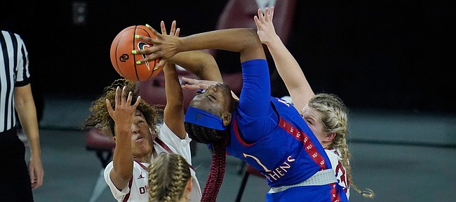 Kansas forward Tina Stephens (1) is defended by Oklahoma guard Gabby Gregory (12), guard Navaeh Tot, left, and guard Tatum Veitenheimer, right, in the first half of an NCAA college basketball game Wednesday, Jan. 27, 2021, in Norman, Okla. (AP Photo/Sue Ogrocki)
