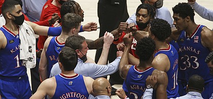 Kansas coach Bill Self meets with players during the second half of an NCAA college basketball game against West Virginia, Saturday, Feb. 6, 2021, in Morgantown, W.Va. (AP Photo/Kathleen Batten)