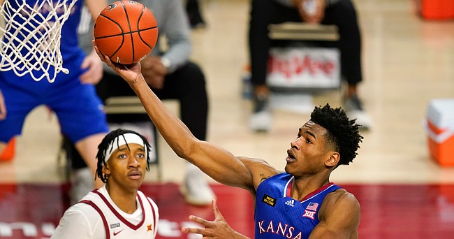 Kansas guard Ochai Agbaji drives to the basket in front of Iowa State guard Jaden Walker, left, during the second half of an NCAA college basketball game, Saturday, Feb. 13, 2021, in Ames, Iowa. Kansas won 64-50. (AP Photo/Charlie Neibergall)