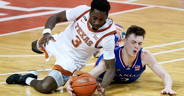 Texas guard Courtney Ramey (3) fights for a loose ball with Kansas guard Christian Braun during overtime in an NCAA college basketball game, Tuesday, Feb. 23, 2021, in Austin, Texas. (AP Photo/Eric Gay)
