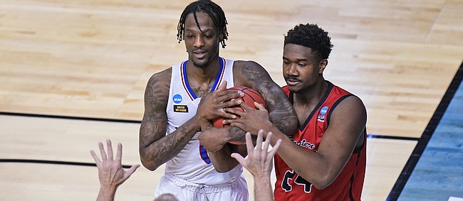 Eastern Washington guard Kim Aiken Jr. (24) and Kansas guard Marcus Garrett, left, battle for the ball during the first half of a first-round game in the NCAA college basketball tournament at Farmers Coliseum in Indianapolis, Saturday, March 20, 2021. (AP Photo/AJ Mast)