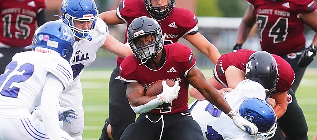 Lawrence High running back Devin Neal puts a move on several Washburn Rural defenders during the first quarter on Friday, Sept. 11, 2020 at Lawrence High School.