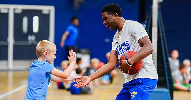 Kansas newcomer Kyle Cuffe slaps hands with a camper as he leads them through drills during Washburn head coach Brett Ballard's basketball camp on Tuesday, June 8, 2021 at Lee Arena in Topeka.