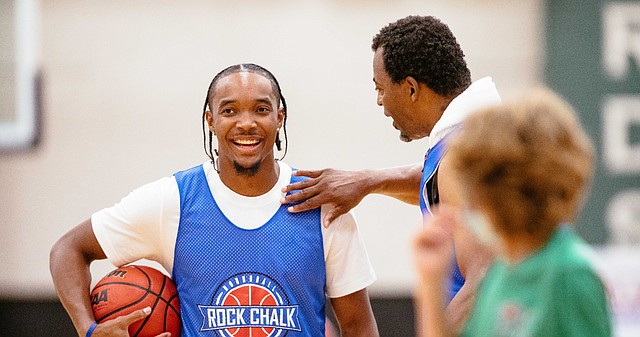 Devonte' Graham talks to former KU great Ron Kellogg while warming up at the Rock Chalk Roundball Classic on Thursday, Aug 5, 2021 at Free State High. 