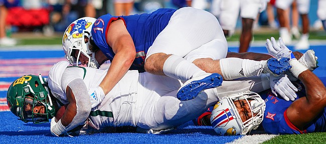 Baylor running back Trestan Ebner (1) falls into the end zone for a touchdown with Kansas linebacker Gavin Potter (19) and Kansas linebacker Nate Betts (0) during the third quarter on Saturday, Sept. 18, 2021 at Memorial Stadium. (Photo by Nick Krug/Special to the Journal-World)