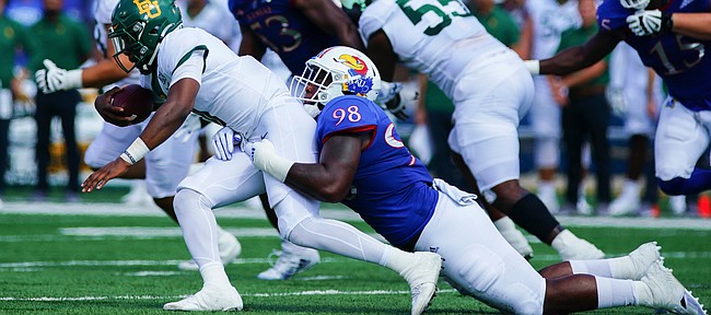 Kansas defensive lineman Caleb Sampson (98) drags down Baylor quarterback Gerry Bohanon (11) during the first quarter on Saturday, Sept. 18, 2021 at Memorial Stadium. (Photo by Nick Krug/Special to the Journal-World)