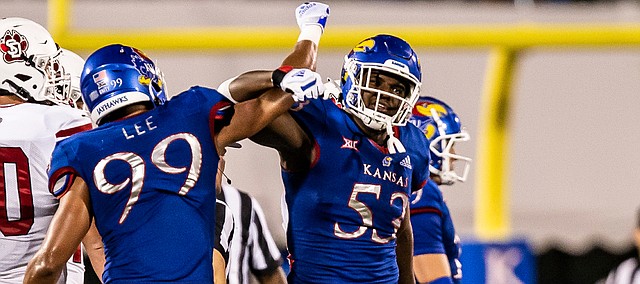 Kansas defensive lineman Caleb Taylor (No. 53) celebrates with defensive end Malcolm Lee (No. 99) after making a play in the Jayhawks' Week 1 win over South Dakota, on Sept. 3, 2021.