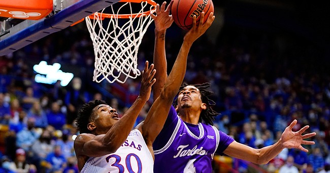 Kansas guard Ochai Agbaji (30) gets a reverse layup past the outstretched arm of Tarleton State guard Tahj Small (4) during the first half on Friday, Nov. 12, 2021 at Allen Fieldhouse.
