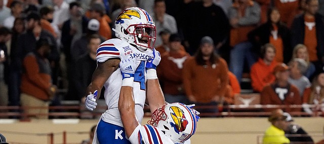 Kansas running back Devin Neal celebrates a touchdown run against Texas with teammate Bryce Cabeldue during the first half of a game in Austin, Texas, on Nov. 13, 2021.