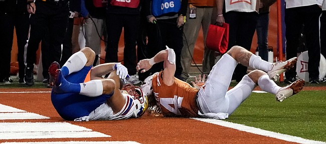 Kansas fullback Jared Casey, left, catches a 2-point conversion past Texas defensive back Brenden Schooler, right, to defeat Texas 57-56 in overtime of an NCAA college football game in Austin, Texas, Saturday, Nov. 13, 2021. (AP Photo/Chuck Burton)