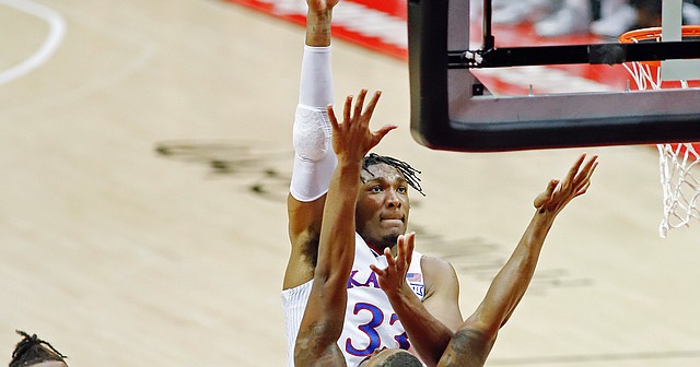 Kansas forward Jalen wilson, left, looks on as teammate David McCormack lays up a shot in over North Texas forward Jahmiah Simmons (10) during the first half of a NCAA college basketball game Thursday, Nov. 25, 2021, in Orlando, Fla.