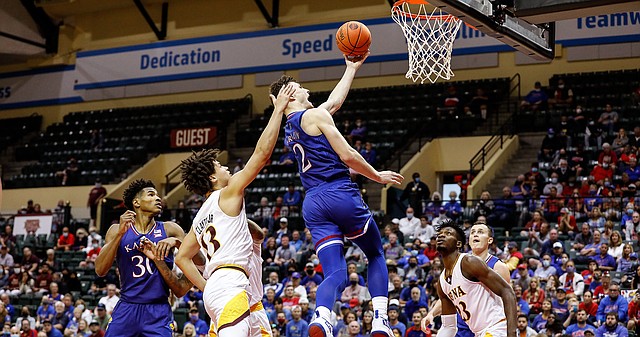 Kansas guard Christian Braun lays up the ball between Iona guard Walter Clayton Jr., front left, and forward Nelly Junior Joseph, front right, during the second half of an NCAA college basketball game Sunday, Nov. 28, 2021, in Lake Buena Vista, Fla. (AP Photo/Jacob M. Langston)