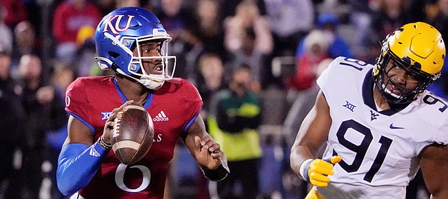 Kansas quarterback Jalon Daniels (6) looks to pass against West Virginia defensive lineman Sean Martin (91) during the first quarter of an NCAA college football game Saturday, Nov. 27, 2021, in Lawrence, Kan. (AP Photo/Ed Zurga)


