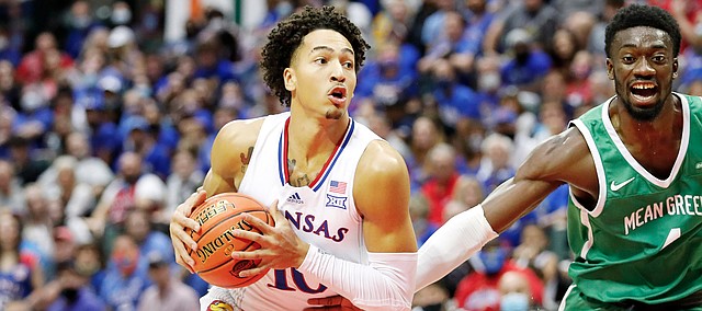 Kansas forward Jalen Wilson, left, drives to the basket in front of North Texas forward Thomas Bell during the first half of a NCAA college basketball game Thursday, Nov. 25, 2021, in Orlando, Fla. 