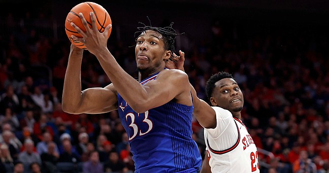 Kansas forward David McCormack (33) drives to the basket past St. John's guard Montez Mathis during the first half of an NCAA college basketball game Friday, Dec. 3, 2021, in Elmont, N.Y. (AP Photo/Adam Hunger)


