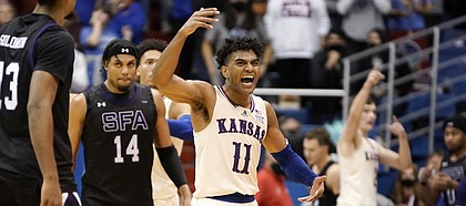Fired up, Kansas guard Remy Martin (11) pumps up the Allen Fieldhouse crowd after hitting a late three-pointer to extend the Jayhawks' lead over Stephen F. Austin on Saturday, Dec. 18, 2021.