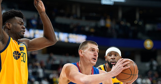 Denver Nuggets center Nikola Jokic, front right, pulls down a rebound as Utah Jazz center Udoka Azubuike, front left, and forward Royce O'Neale defend during the first half of an NBA basketball game Wednesday, Jan. 5, 2022, in Denver. (AP Photo/David Zalubowski)


