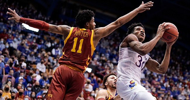 Kansas guard Ochai Agbaji (30) ducks under Iowa State Cyclones guard Tyrese Hunter (11) for a bucket during the second half on Tuesday, Jan. 11, 2022 at Allen Fieldhouse.