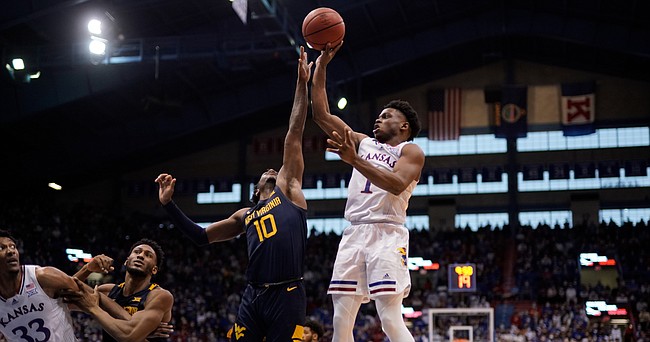 Kansas guard Joseph Yesufu (1) goes up for a shot over West Virginia guard Malik Curry (10) during the second half on Saturday, Jan. 15, 2022 at Allen Fieldhouse.