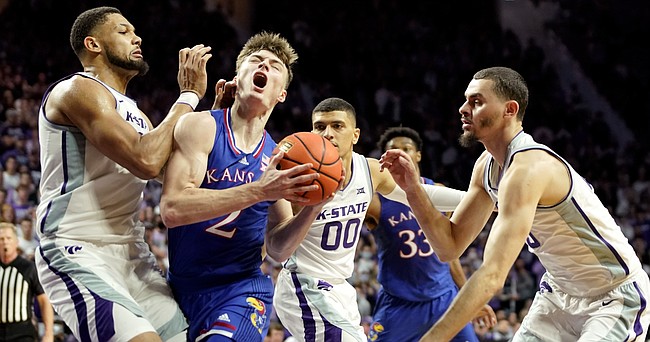 Kansas guard Christian Braun (2) takes some contact from Kansas State forward Davion Bradford (21) as he drives to the bucket during the first half on Saturday, Jan. 22, 2022 at Bramlage Coliseum.