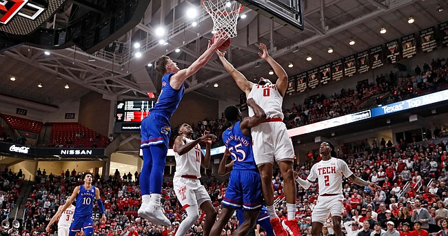 Kansas' Christian Braun (2) and Texas Tech's Kevin Obanor (0) try to rebound the ball during the second half of an NCAA college basketball game on Saturday, Jan. 8, 2022, in Lubbock, Texas. (AP Photo/Brad Tollefson)