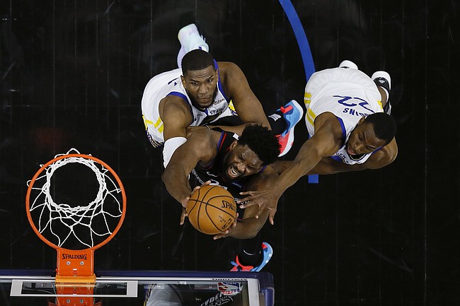 Philadelphia 76ers' Joel Embiid, center, goes up for a shot between Golden State Warriors' Kevon Looney, left, and Andrew Wiggins during the first half of an NBA basketball game, Monday, April 19, 2021, in Philadelphia. (AP Photo/Matt Slocum)


